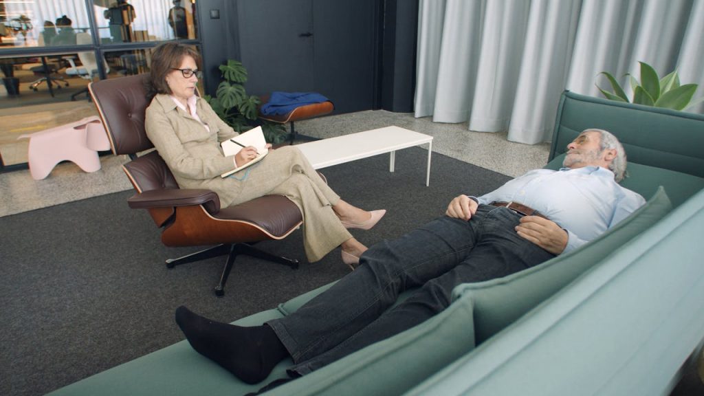 Crafting Captivating Headlines: Your awesome post title goes here A therapist taking notes while a patient lies on a sofa during a counseling session.